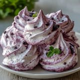 Light and delicate meringue cookies infused with vibrant black currant powder, offering a sweet-tart burst in every bite.