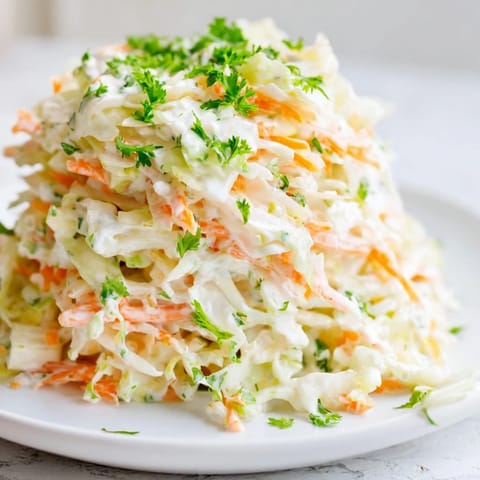 Creamy Coleslaw with Apple, offering a close-up of the dressed salad, showcasing the sweet and tangy apple pieces.