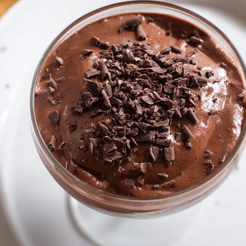 Individual servings of chocolate pudding topped with whipped cream, ready to enjoy.