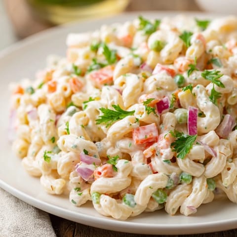 Macaroni salad, chilled and creamy, with colorful bell peppers and tender pasta ready to serve.