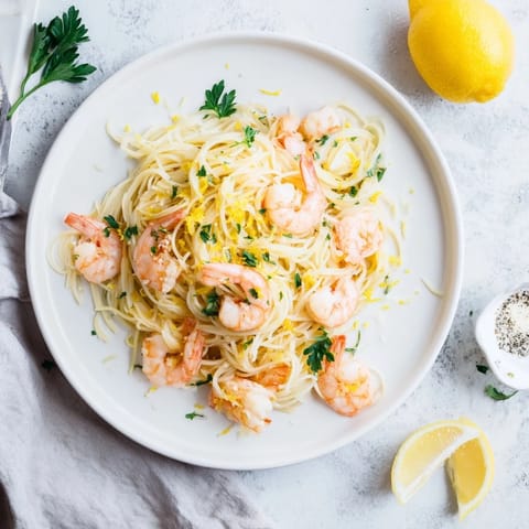 Zesty Lemon Butter Shrimp Pasta Lite with angel hair, sautéed garlic, and succulent pink shrimp.  
