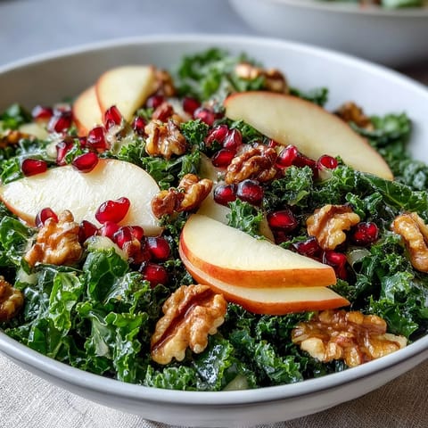 Fresh kale massaged until tender, topped with juicy pomegranate seeds, crisp apple slices, and crunchy walnuts in this vibrant Kale and Pomegranate Bowl.