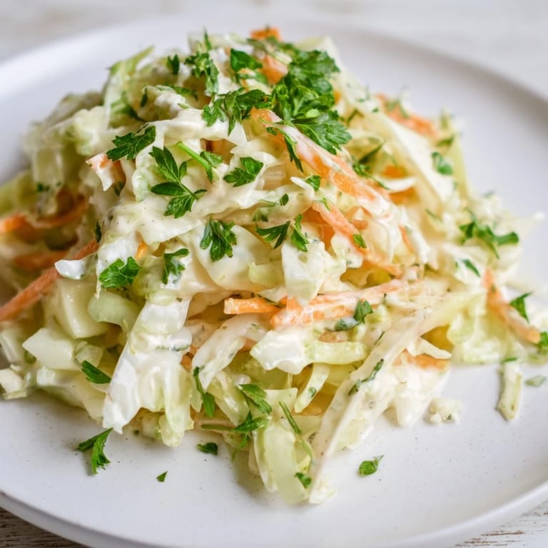 A bowl of bright Coleslaw with Apple, a perfect side dish with hints of sweetness, ready to be enjoyed.