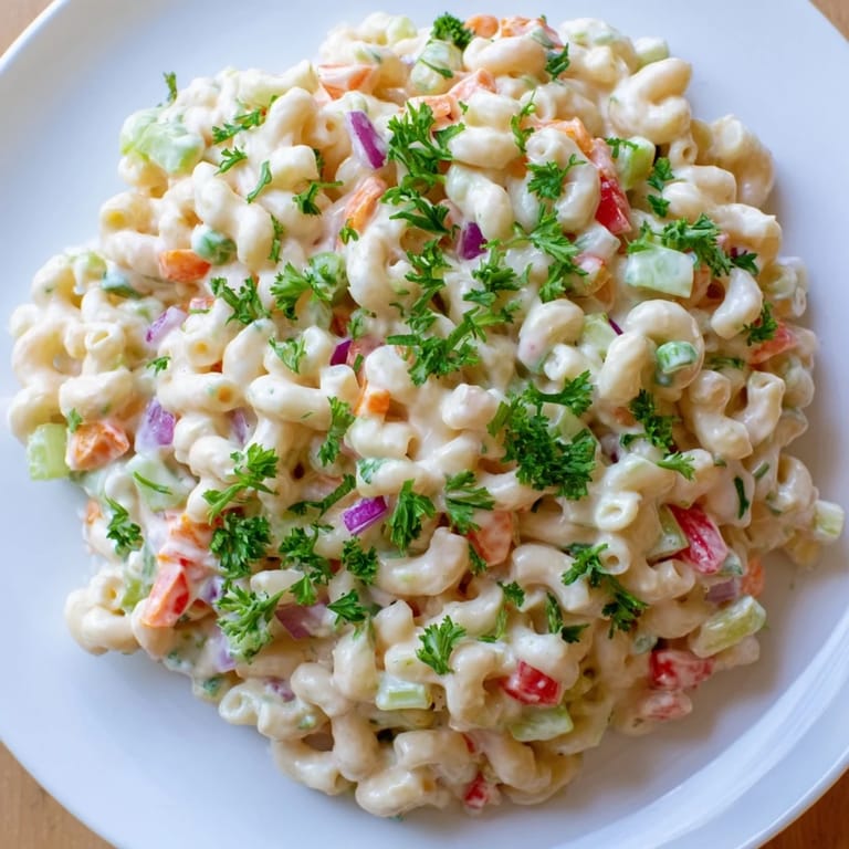 Homemade macaroni salad, featuring elbow macaroni and crisp vegetables, ready to be enjoyed.